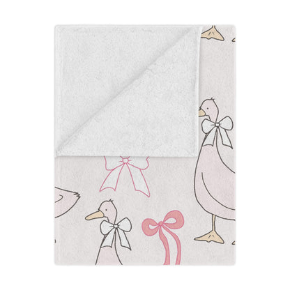 Ribbon Goose minky baby blanket draped over a crib
