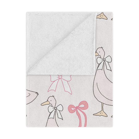 Ribbon Goose minky baby blanket draped over a crib