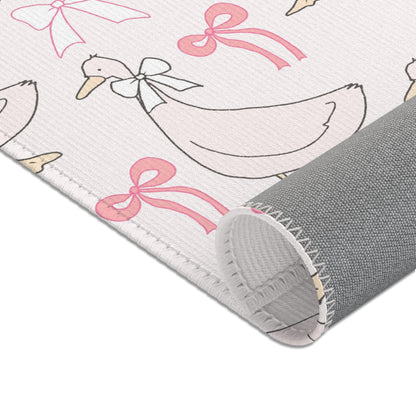 Pink goose nursery rug under a crib