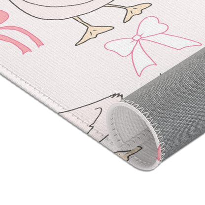 Blush goose print rug beside a nursery glider chair