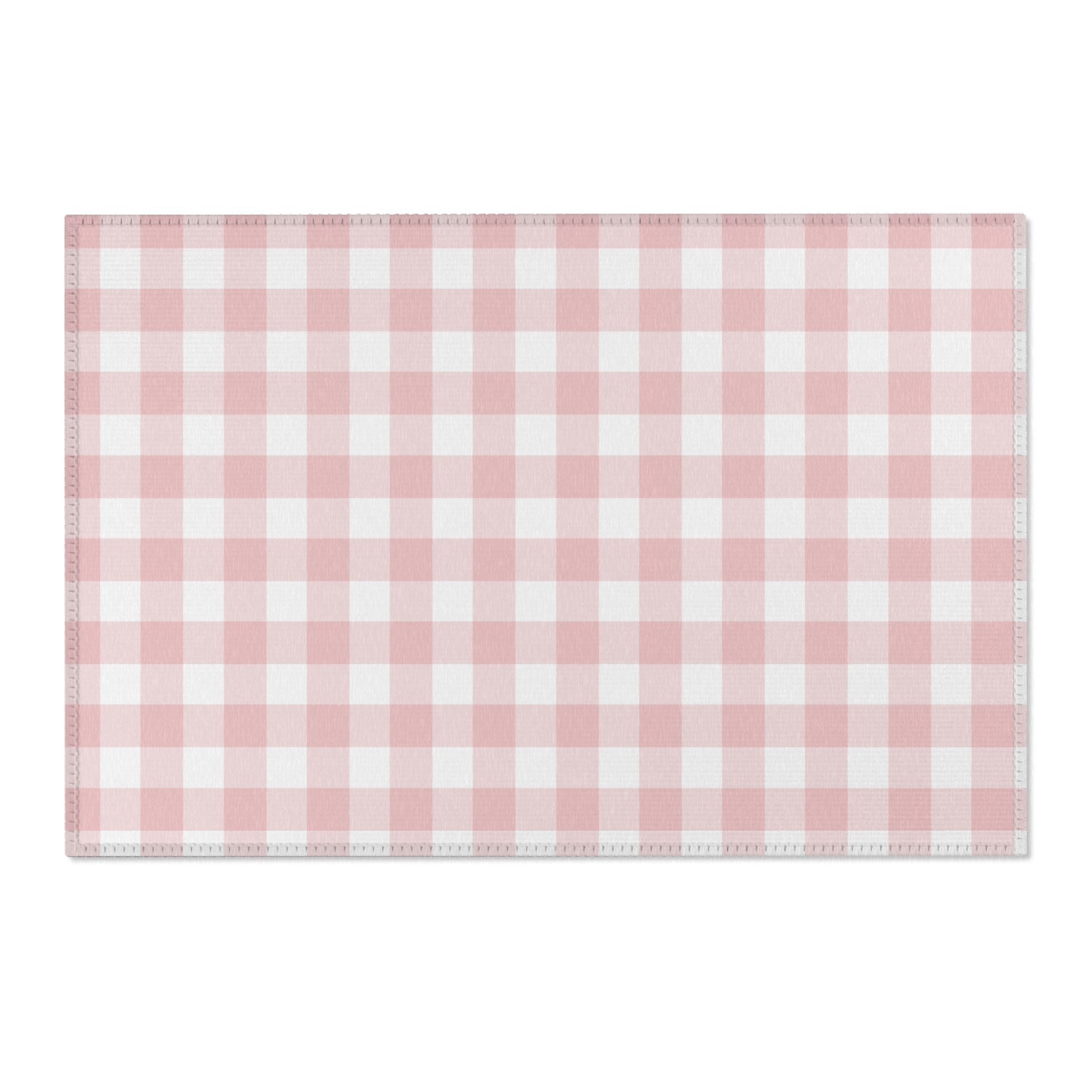 Pink gingham area rug beside a nursery crib