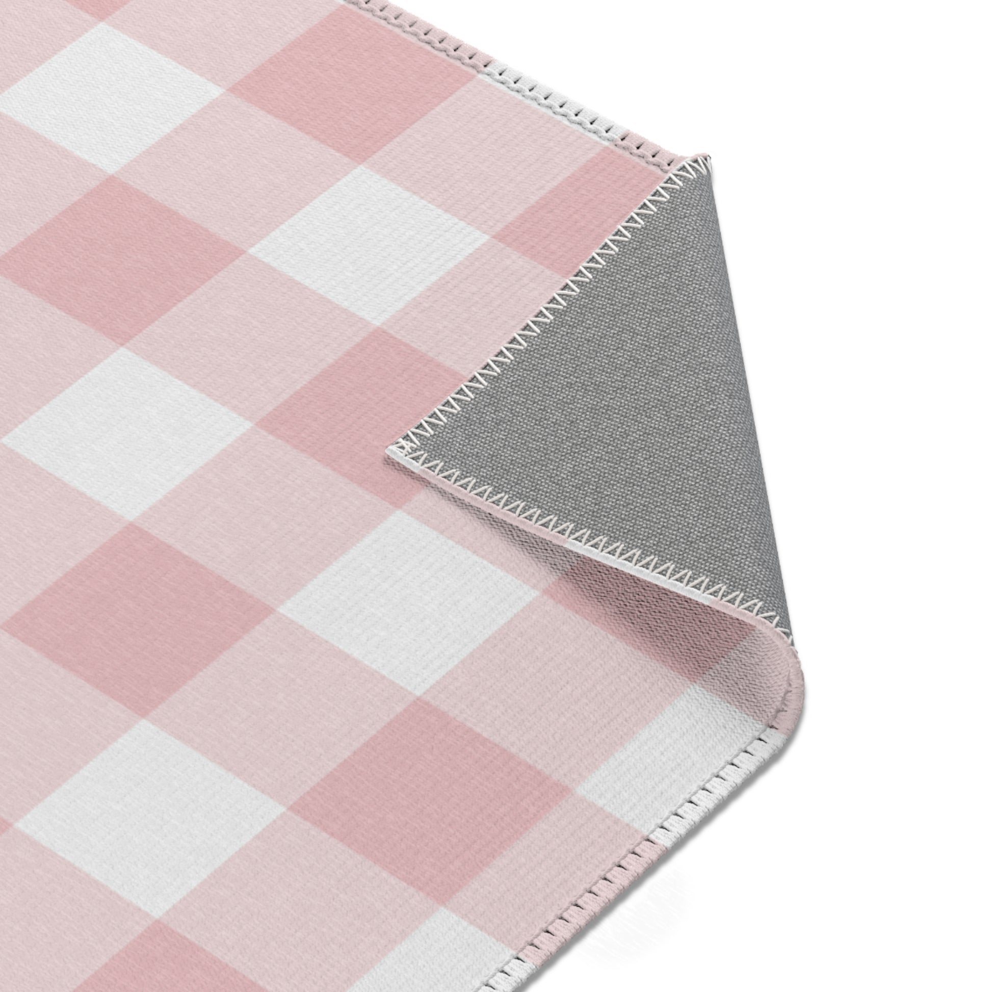 Rose Gingham rug seen from above in a nursery