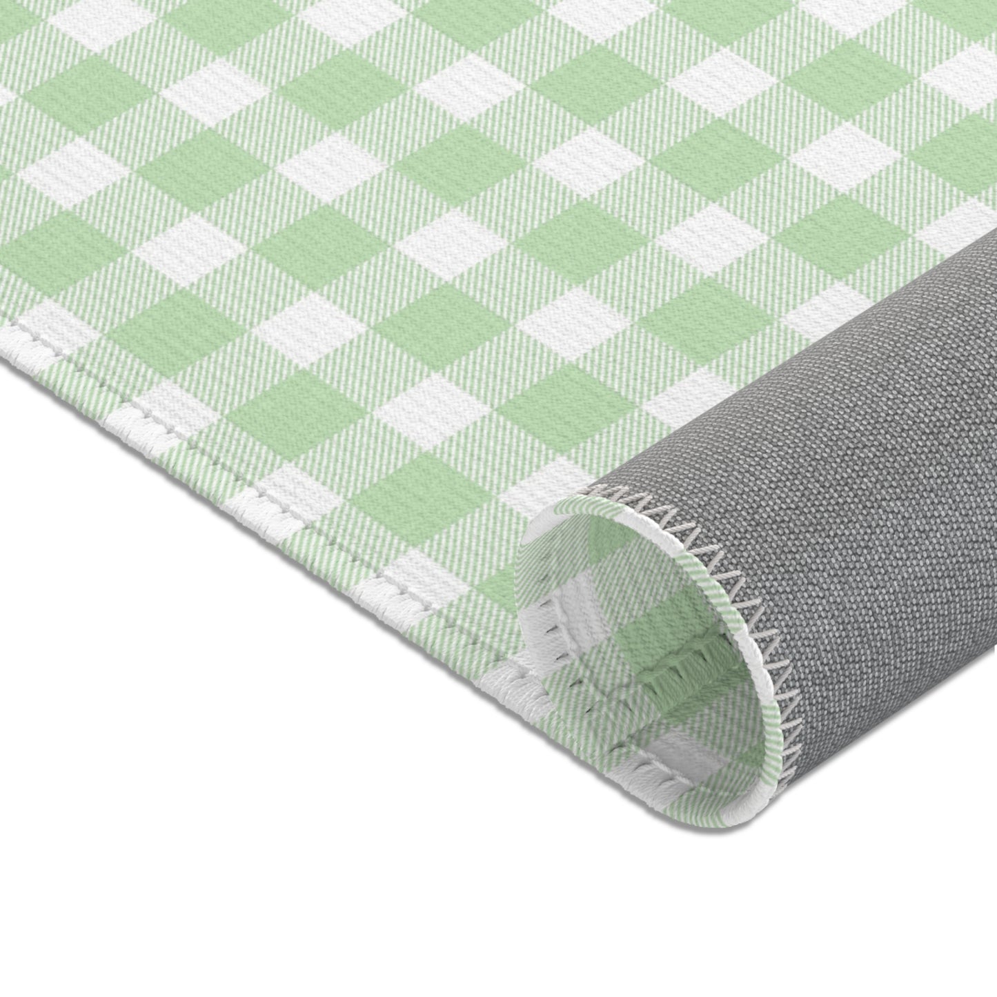 Sage green check rug beside a nursery glider chair