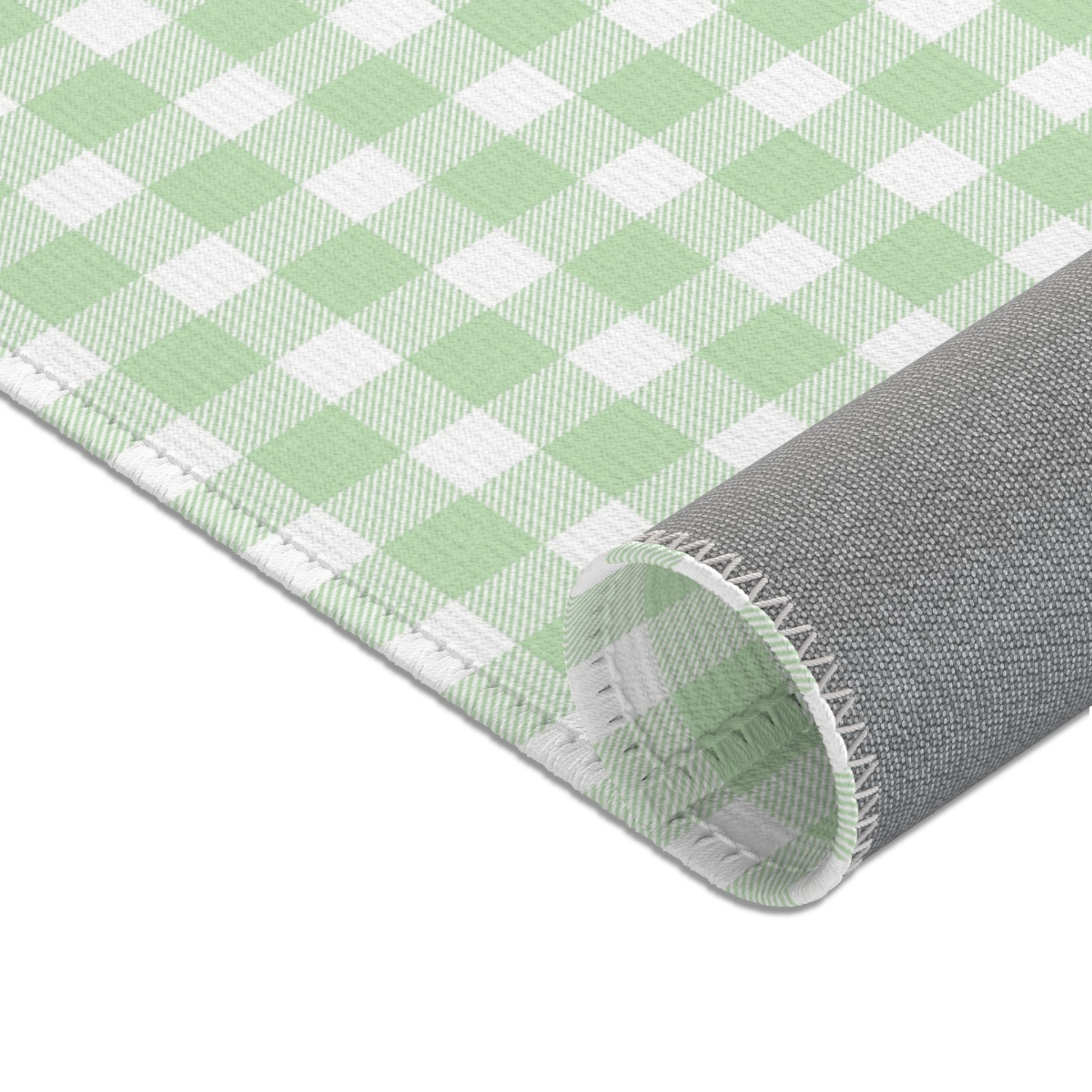 Sage green check rug beside a nursery glider chair