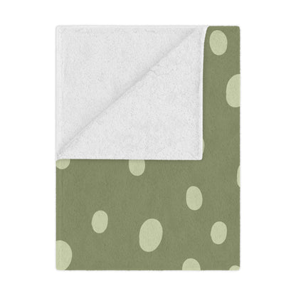 Sage Speckle minky baby blanket draped over a crib