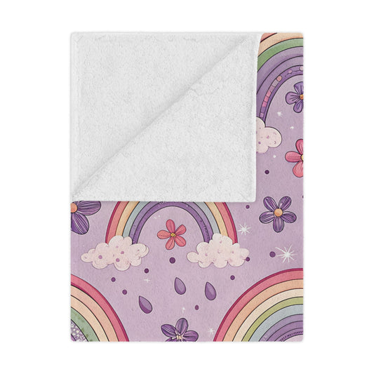 Violet Sky Rainbows minky baby blanket draped over a crib