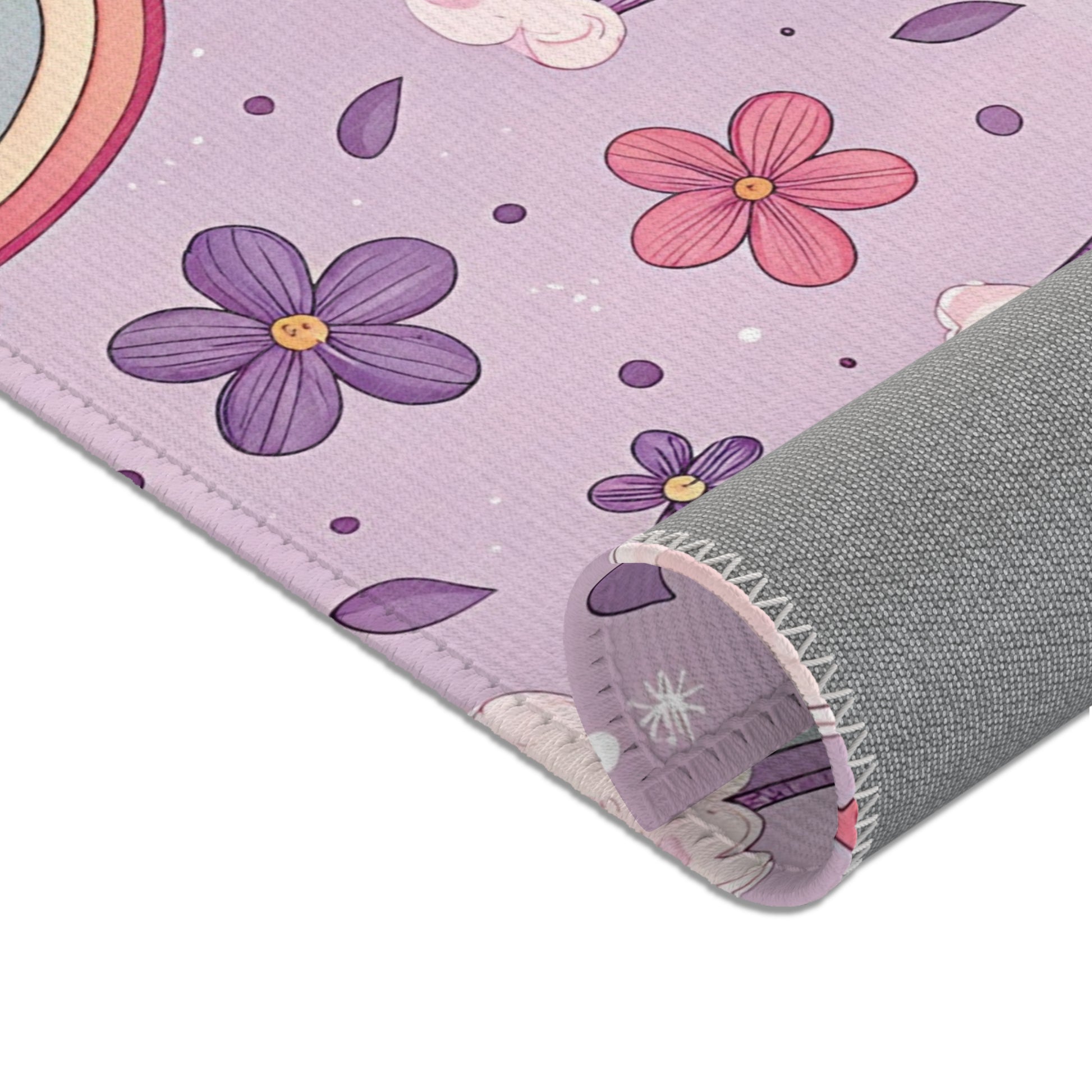 Rainbows, clouds and small flowers across the nursery area rug