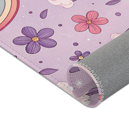 Rainbows, clouds and small flowers across the nursery area rug