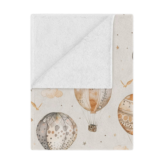 Wandering Balloons minky baby blanket draped over a crib